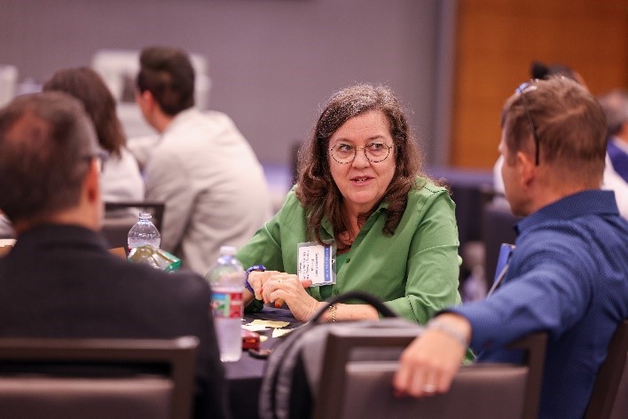 Woman and man conversing at a table during the conference.